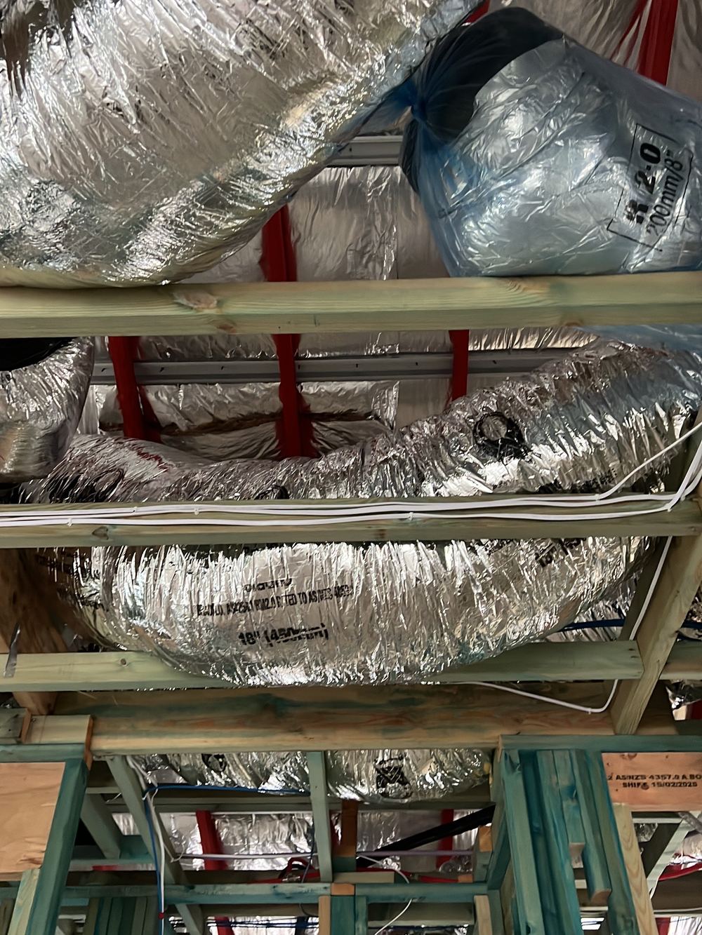 Flexible ducts lying on the ceiling framing rather than hung on supports, Kellyville, Tallawong